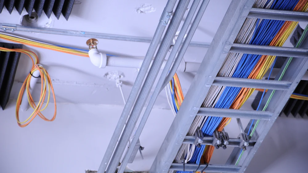 Cable tray carrying wiring across a commercial ceiling.