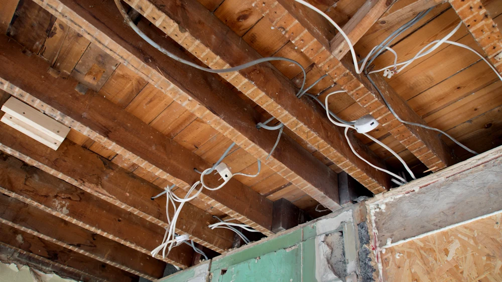 New wiring run through open ceiling joists during a whole-home rewire.
